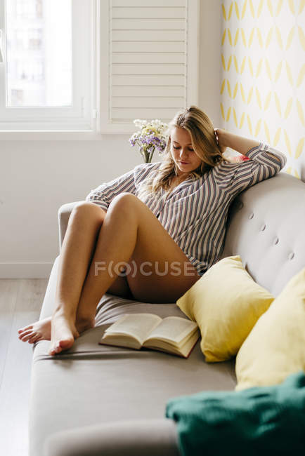 Young pensive woman in casual shirt at home — Stock Photo