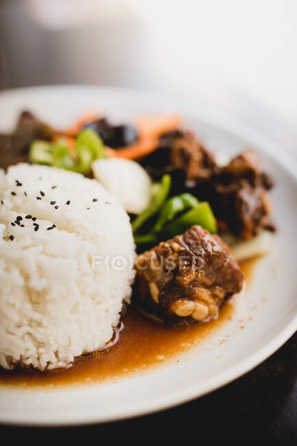 Préparé de délicieuses côtes de porc chaud avec du riz et des légumes sains comme le concombre et l'oignon sur l'assiette dans un restaurant asiatique — Photo de stock