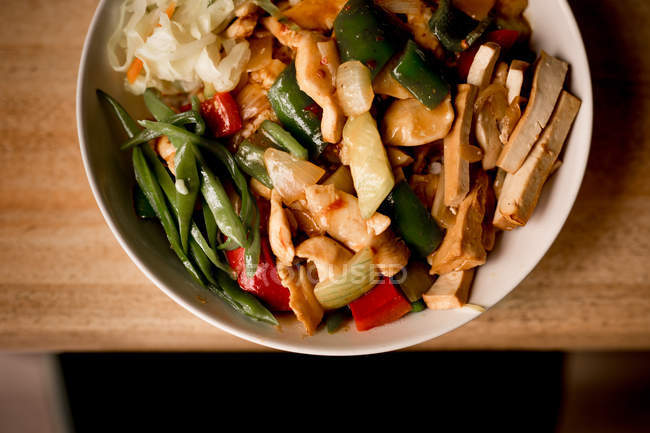 Bol de plat végétarien savoureux avec des légumes sur une table en bois — Photo de stock