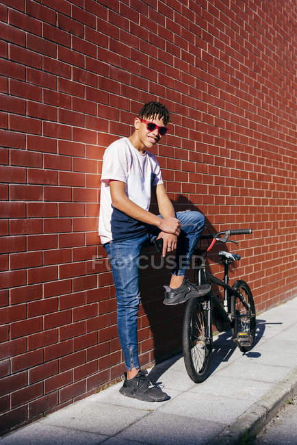 Young happy black man leaning on wall — Stock Photo