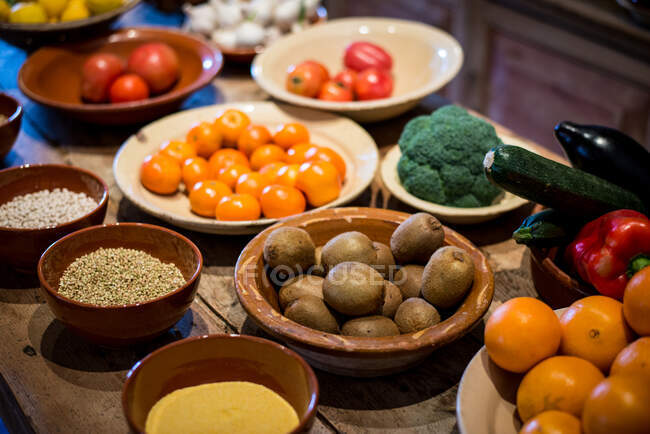 Ancient village cottage cellar bowls of healthy natural vegetables and juicy ripe fruits — Stock Photo