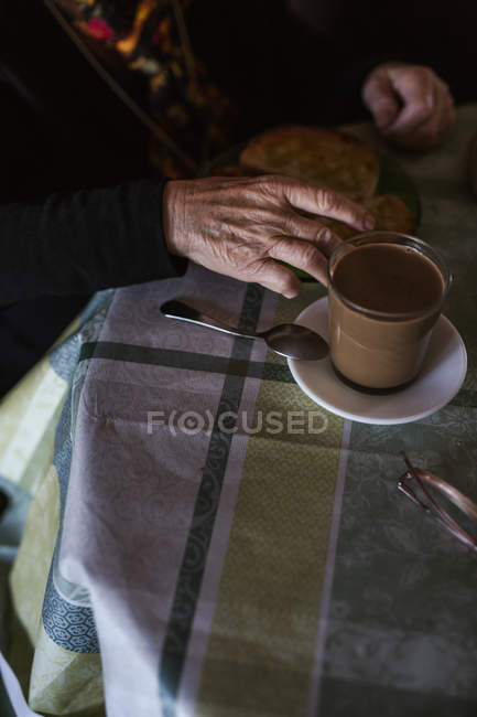 Cropped image of woman having breakfast while sitting at table — Stock Photo