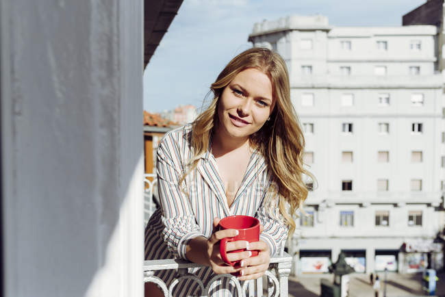 Jeune femme avec tasse sur terrasse — Photo de stock