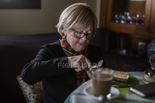 Senior attractive woman taking medication from pill box before breakfast — Stock Photo