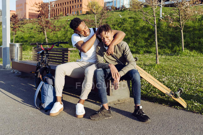 Молодые афроамериканцы играют на уличной скамейке — стоковое фото