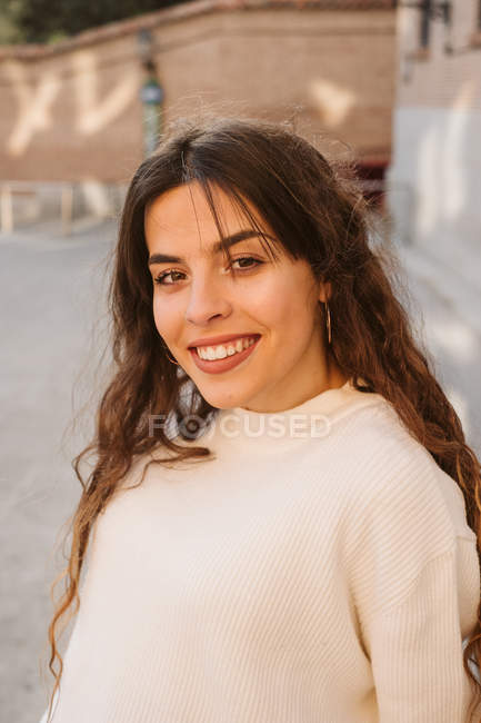 Hübsche junge Frau, die im Freien in die Kamera lächelt — Stockfoto
