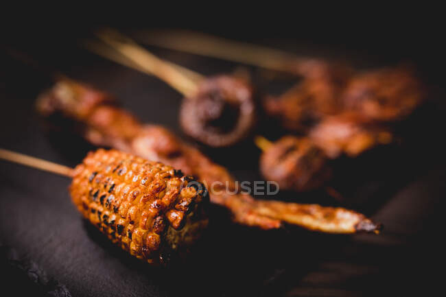 Delicious grilled hot skewers with natural corn, healthy mushrooms and meat on table in restaurant — Fotografia de Stock