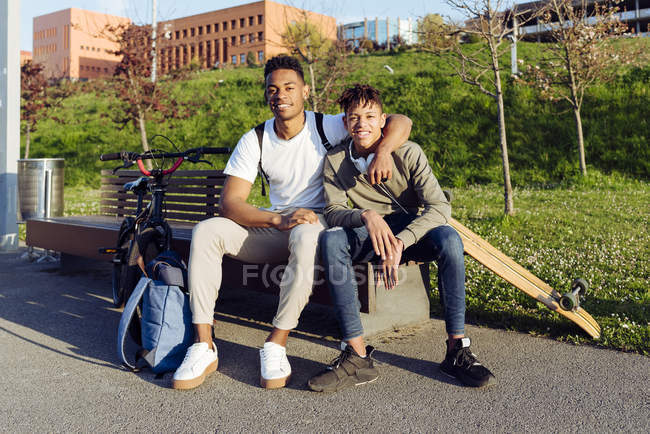 Jeunes hommes afro-américains jouant sur banc de rue — Photo de stock