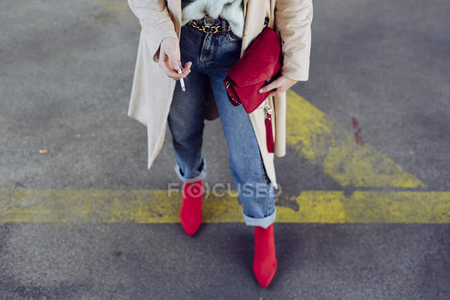 Closeup of stylish woman standing on street road with cigarette — Stock Photo