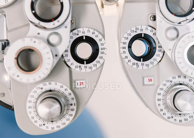 Modern vision test equipment and chair against white wall in optician office in clinic — Stock Photo