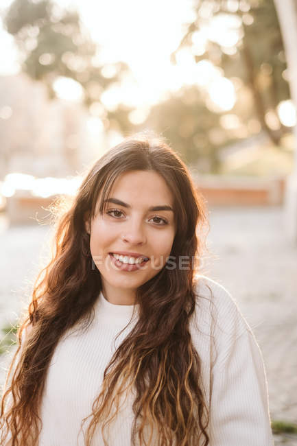 Muito jovem mulher sorrindo e olhando para a câmera ao ar livre — Fotografia de Stock