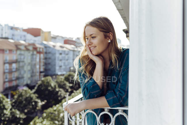 Mujer joven mirando hacia otro lado en balcón - foto de stock