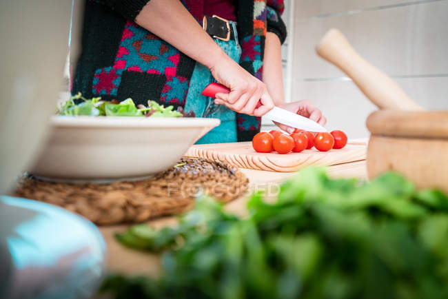Imagem cortada de mulher cortando tomates enquanto cozinha salada saudável na cozinha — Fotografia de Stock