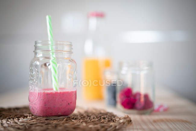 Recipientes com bagas frescas e bebidas saudáveis colocadas na mesa — Fotografia de Stock