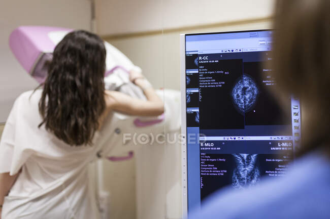 Paciente femenina junto a la unidad de mamografía digital - foto de stock