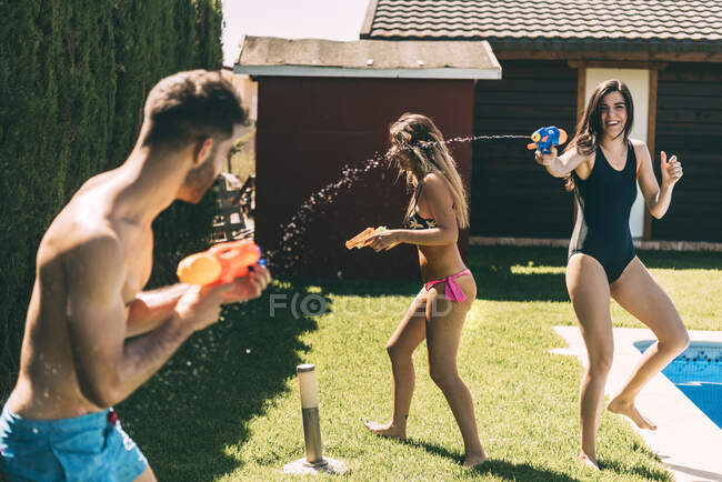 Amigos salpicando com armas de água — Fotografia de Stock