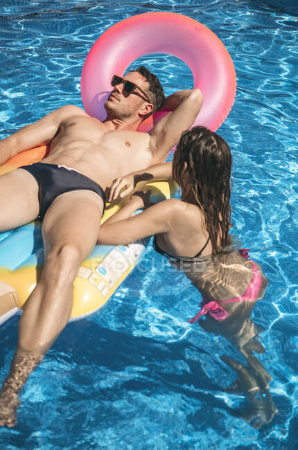 Hombre y mujer relajándose en la piscina - foto de stock