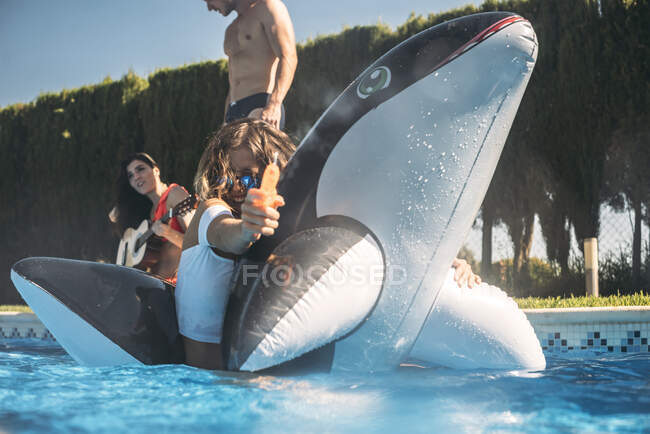 Девушка плавает и использует водяной пистолет — стоковое фото