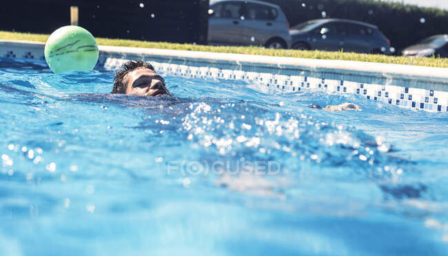 Homem flutuando na piscina — Fotografia de Stock