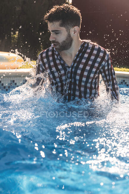 Hombre vestido en la piscina - foto de stock