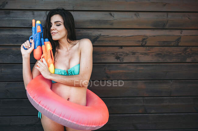 Junge Frau posiert mit zwei Wasserpistolen — Stockfoto