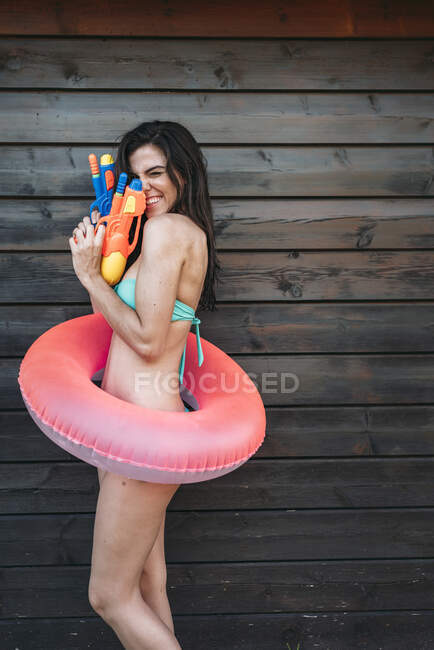 Giovane signora con due pistole ad acqua posa — Foto stock