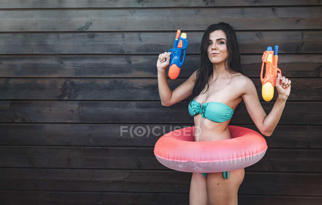 Jeune femme avec deux pistolets à eau posant — Photo de stock