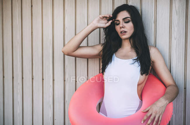 Girl with a swimming ring posing by white wooden fence — Stock Photo