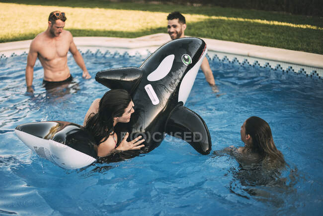 Друзі плавають на надувній іграшці в басейні — стокове фото