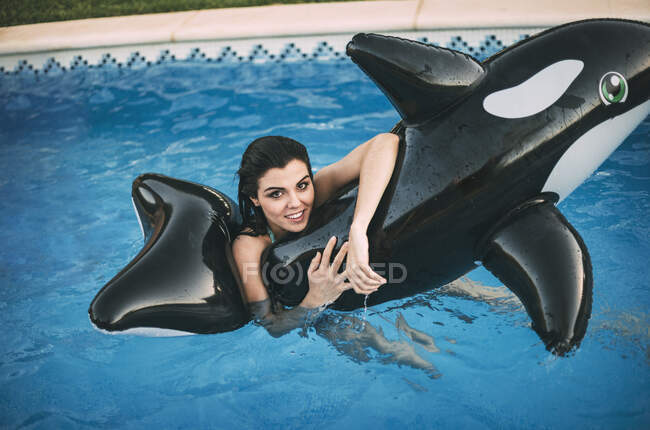 Chica con juguete inflable posando en el agua - foto de stock