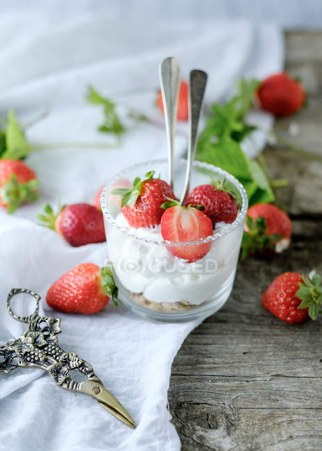 Creamy sweet dessert with fresh juicy strawberries served in glass on rustic wooden table — Stock Photo