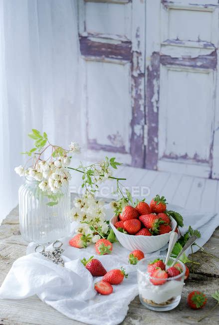 Cremig-süßes Dessert mit frischen saftigen Erdbeeren im Glas auf rustikalem Holztisch serviert — Stockfoto