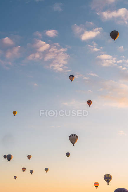 Heißluftballons fliegen während des Festivals in Kappadokien gegen den sonnigen Abendhimmel — Stockfoto