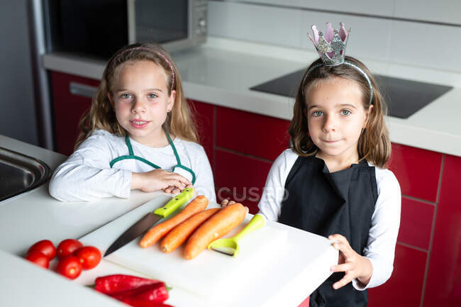 Petites filles prêtes à commencer à préparer une salade saine dans la cuisine ensemble — Photo de stock