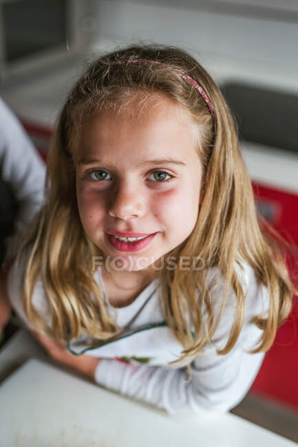 Retrato de menina bonito olhando para câmera dentro de casa — Fotografia de Stock
