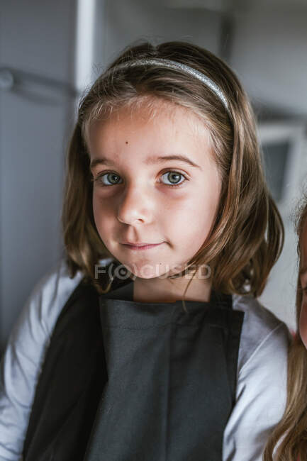 Портрет милой молодой девушки, смотрящей в камеру в помещении — стоковое фото