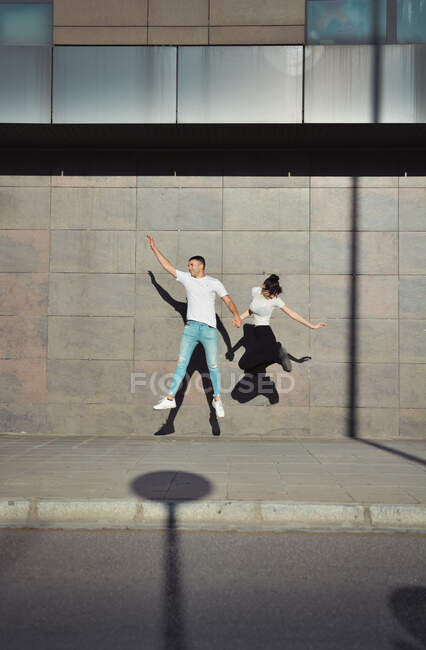 Coppia che salta per la gioia nelle strade della città — Foto stock