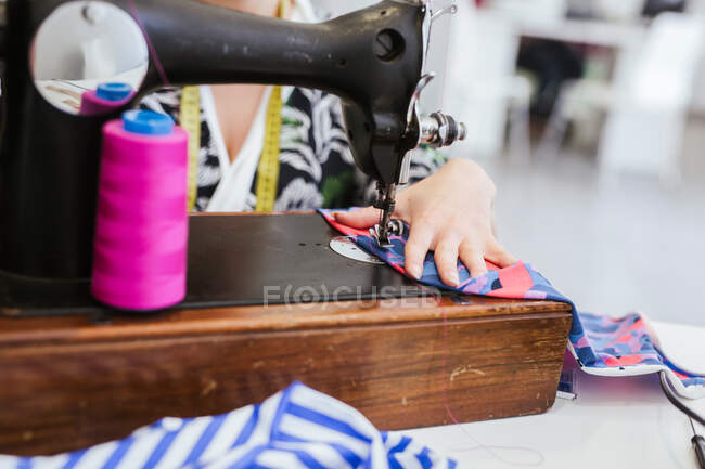 Primer plano de la mujer de costura en la máquina en el taller - foto de stock