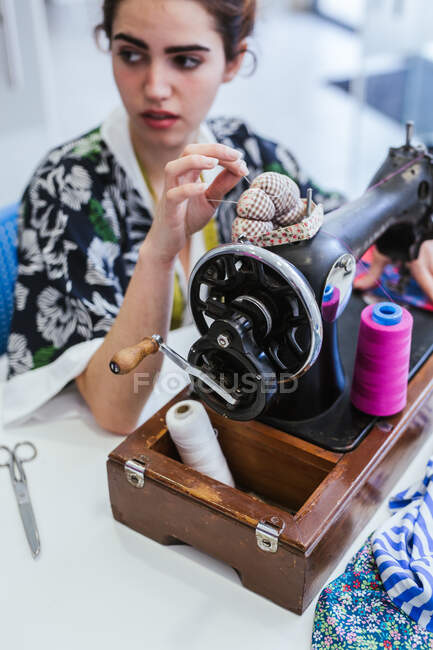 Teenage girl student practicing sewing on modern machine in cozy workshop — Stock Photo