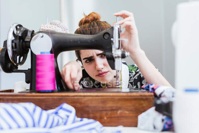 Teenagermädchen üben Nähen an moderner Maschine in gemütlicher Werkstatt — Stockfoto