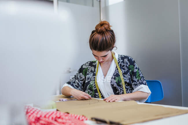 Adolescente estudiante practicando costura en la máquina moderna en acogedor taller - foto de stock