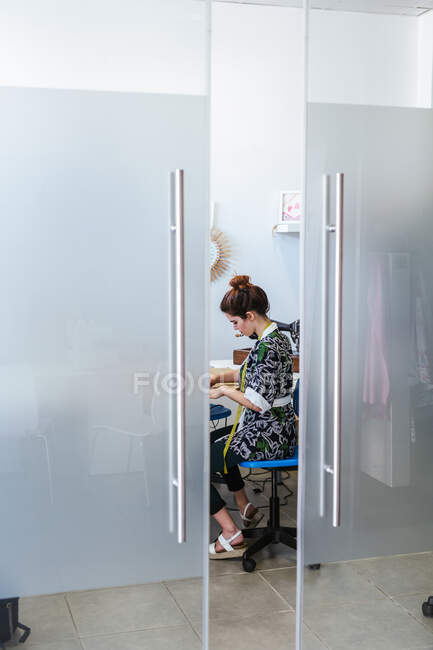 Teenagermädchen üben Nähen an moderner Maschine in gemütlicher Werkstatt — Stockfoto