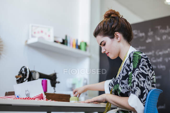 Estudante adolescente praticando costura na máquina moderna em oficina acolhedora — Fotografia de Stock
