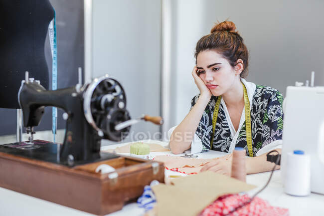 Étudiante adolescente pratiquant la couture sur une machine moderne dans un atelier confortable — Photo de stock