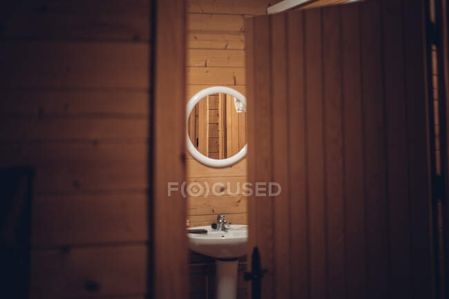 Ванная комната в деревянном доме с открытой дверью — стоковое фото