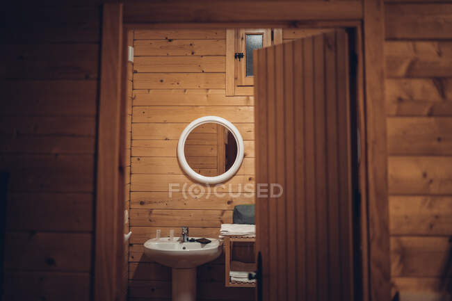 Banheiro acolhedor em casa de madeira com porta aberta e equipamento moderno — Fotografia de Stock
