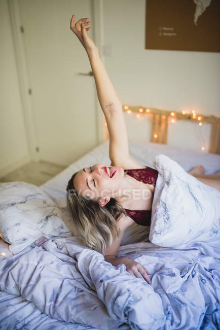 Junge fröhliche Frau in Unterwäsche morgens im Bett — Stockfoto