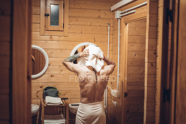 Mann steigt aus der Dusche und trocknet sich die Haare mit dem Handtuch — Stockfoto
