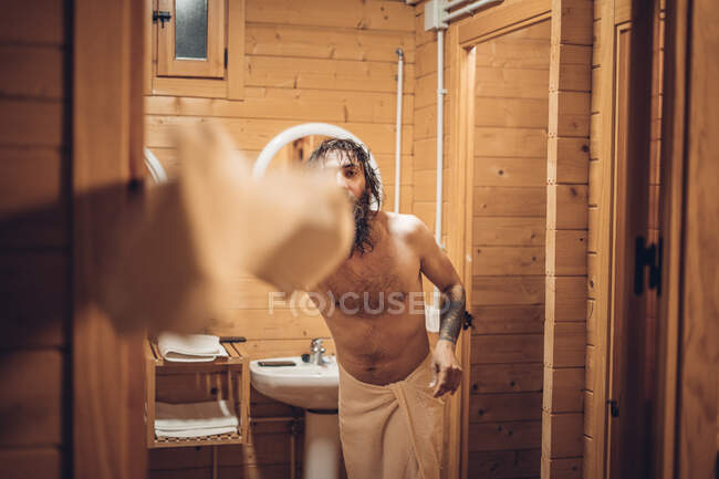 Bearded man throwing towel after bathing — Stock Photo