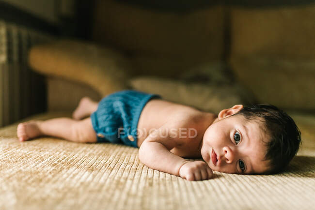 Niedliche kleine unschuldige Neugeborene in Rücken liegend auf Sofa zu Hause — Stockfoto